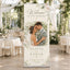 A personalized vertical roll-up banner stand displayed in a wedding reception hall. The banner features a custom printed design with a couple's wedding photo, floral watercolor borders, and the text 'Welcome to our wedding' and 'Olivia & Ethan'.