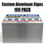 A stack of custom aluminum safety signs with a prominent 'SAFETY FIRST' notice panel on top, shown against a white background with the text 'Custom Aluminum Signs 100 PACK' at the top.