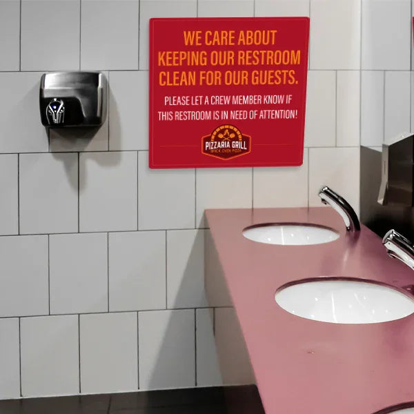 ⁠A red commercial PVC plastic sign mounted on a tiled restroom wall above a sink countertop.⁠