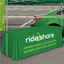 Fitted green 4-foot custom table throw with white rideshare logo used at an outdoor event.