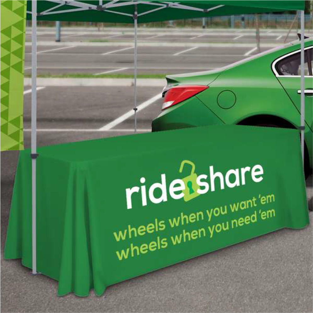 Fitted green 4-foot custom table throw with white rideshare logo used at an outdoor event.
