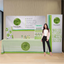 Full trade show display featuring an 8-foot custom table throw and matching green backdrop banner.
