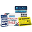 A collection of custom business signs including directional parking, holiday sale banners, and yellow no trespassing security signs.