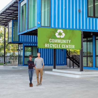 A green community recycling center promotional vinyl banner mounted to the exterior facade of a modern blue shipping container building.⁠