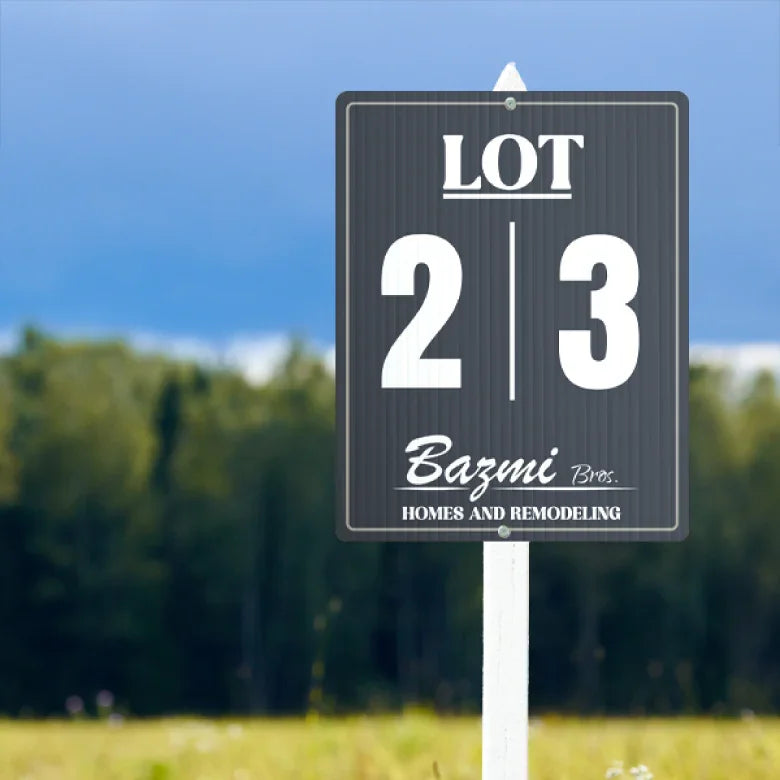 Black and white custom corrugated plastic lot sign mounted on a white stake in a field.