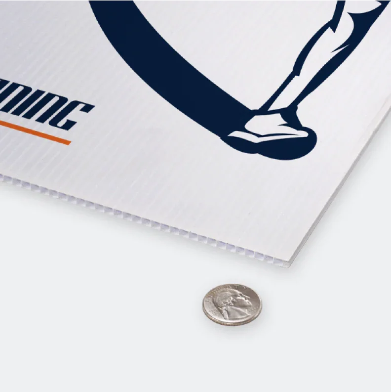 Close up view of corrugated plastic sign thickness compared to a coin for scale.