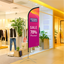 Custom pink advertising feather flag for retail store sales and indoor business promotion.