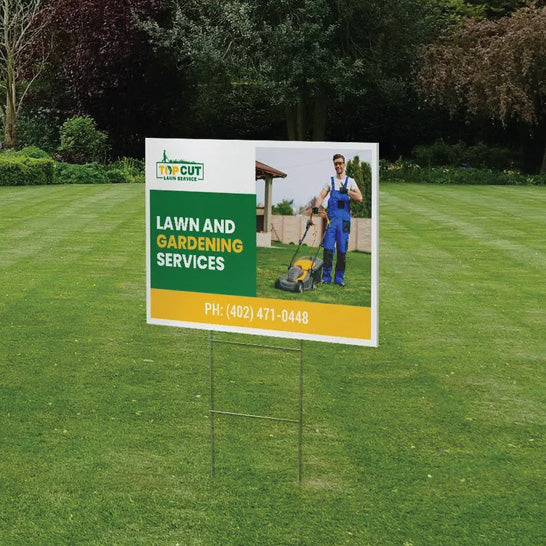 A green custom printed lawn care and landscaping service corrugated yard sign standing on a freshly mowed grass yard.