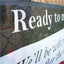 Close-up shot of a custom printed mesh banner attached to a metal fence, showing the clean text printing.⁠