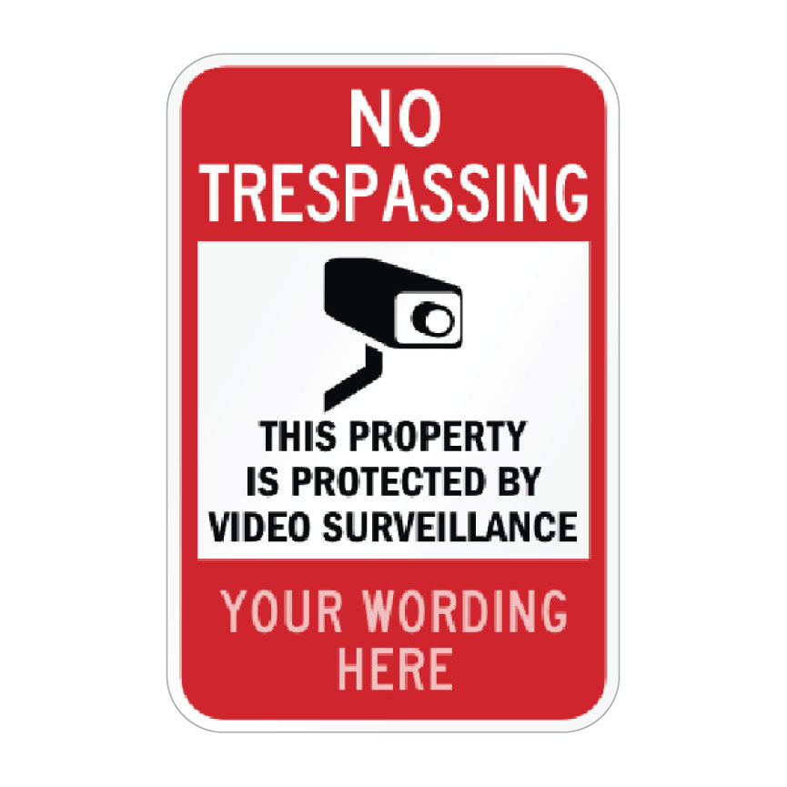 A customizable red and white 'No Trespassing' security sign with a black video camera icon and placeholder text 'YOUR WORDING HERE'.