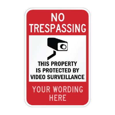 A customizable red and white 'No Trespassing' security sign with a black video camera icon and placeholder text 'YOUR WORDING HERE'.