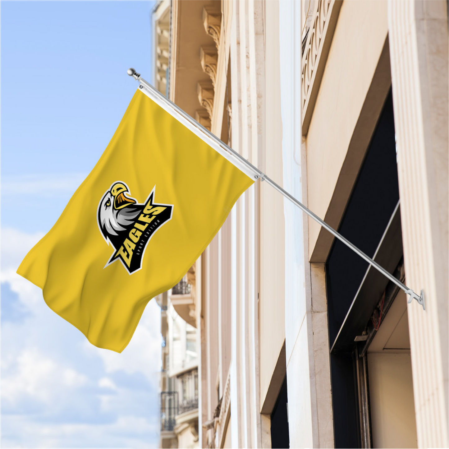 Custom yellow outdoor flag with black logo mounted on a building wall using a silver pole.