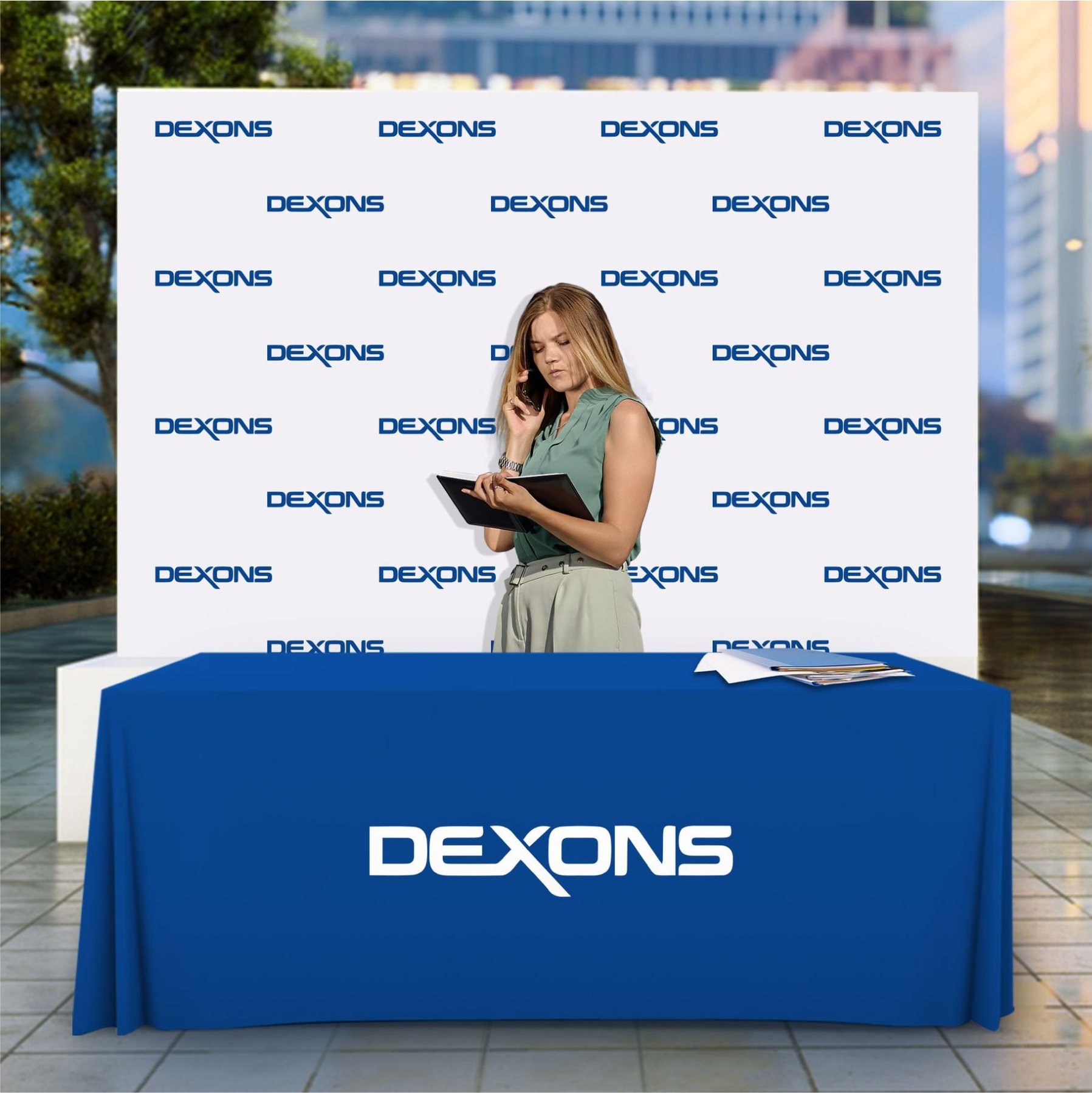 Custom blue 4-foot promotional table throw with white corporate branding paired with a matching step and repeat logo backdrop banner for trade shows.
