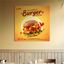 Square custom PVC sign featuring a vibrant burger graphic mounted on a restaurant wall above the seating area.⁠
