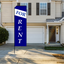 A tall blue rectangle advertising flag with white "For Rent" text standing on a residential driveway next to a house garage.