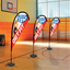 Orange custom teardrop flag banners reading Get Fit standing on an indoor basketball court gym floor.⁠