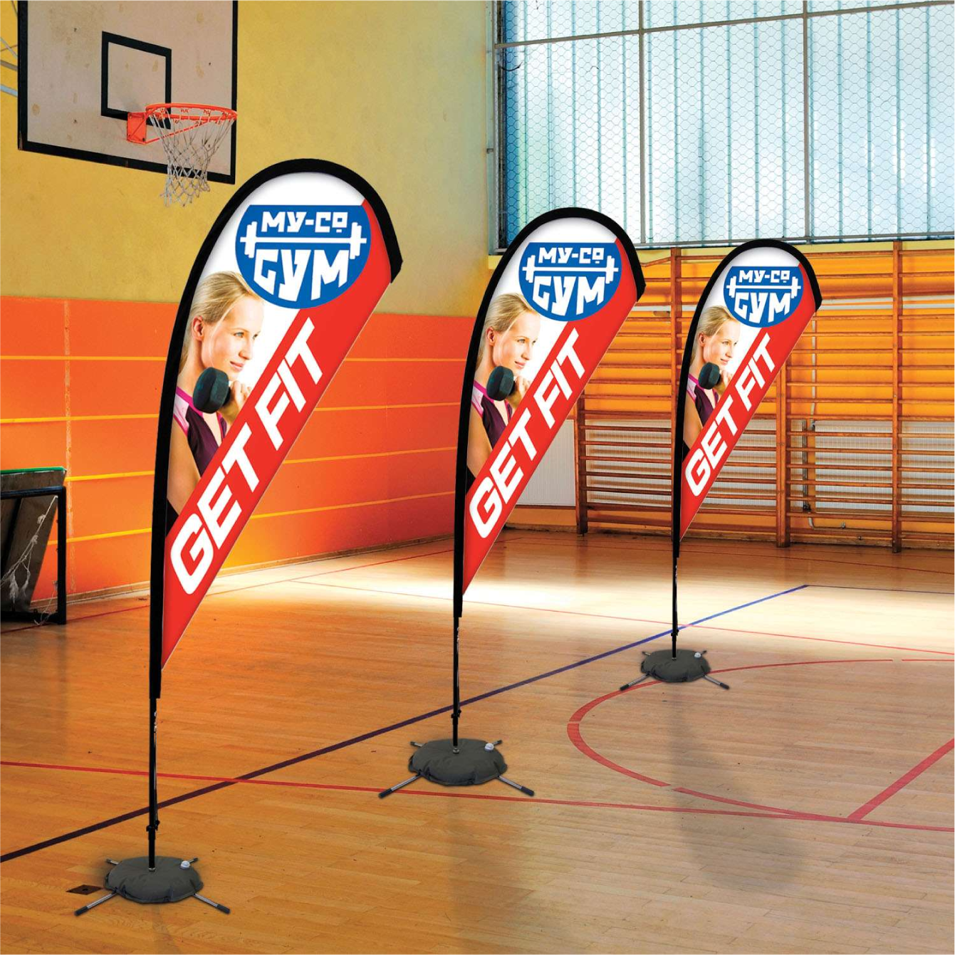 Orange custom teardrop flag banners reading Get Fit standing on an indoor basketball court gym floor.⁠