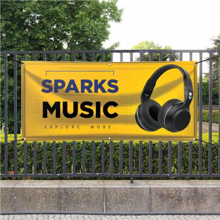 A bright yellow custom vinyl banner advertising a music store mounted to a black outdoor metal fence.⁠