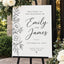 Modern minimalist custom wedding welcome sign placed on a black easel for a wedding ceremony entrance.