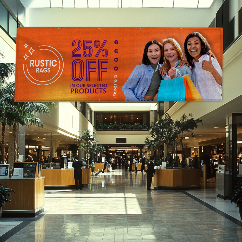 A large horizontal indoor retail promotion vinyl banner hanging from the ceiling over a busy shopping mall corridor.