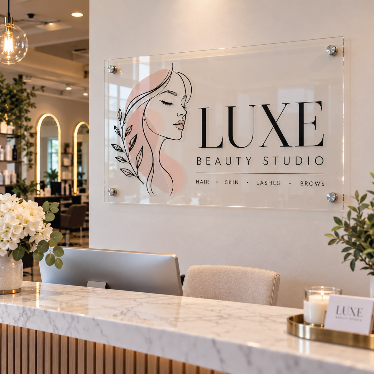 Professional glass-look acrylic reception sign featuring "LUXE BEAUTY STUDIO" in crisp black and gold typography, mounted on a modern office wall above a reception desk.
