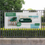 A green and white commercial advertising mesh banner mounted cleanly to an outdoor metal perimeter fence.
