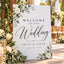 Modern minimalist custom wedding welcome sign placed on a wooden stand for a wedding ceremony entrance.
