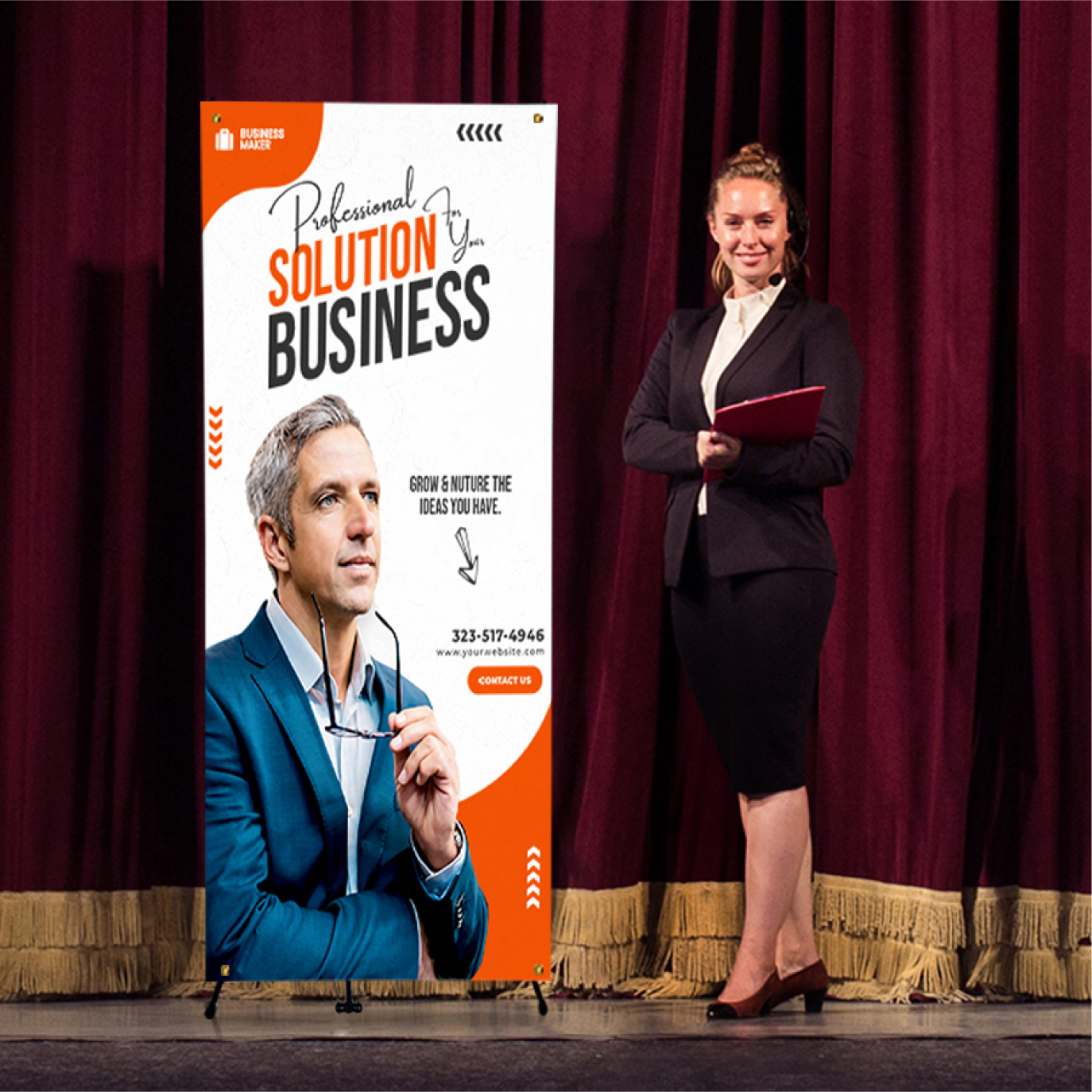 An orange corporate presentation X-banner stand positioned on a stage next to a speaker in front of a red curtain background.⁠