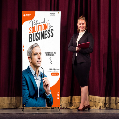 An orange corporate presentation X-banner stand positioned on a stage next to a speaker in front of a red curtain background.⁠