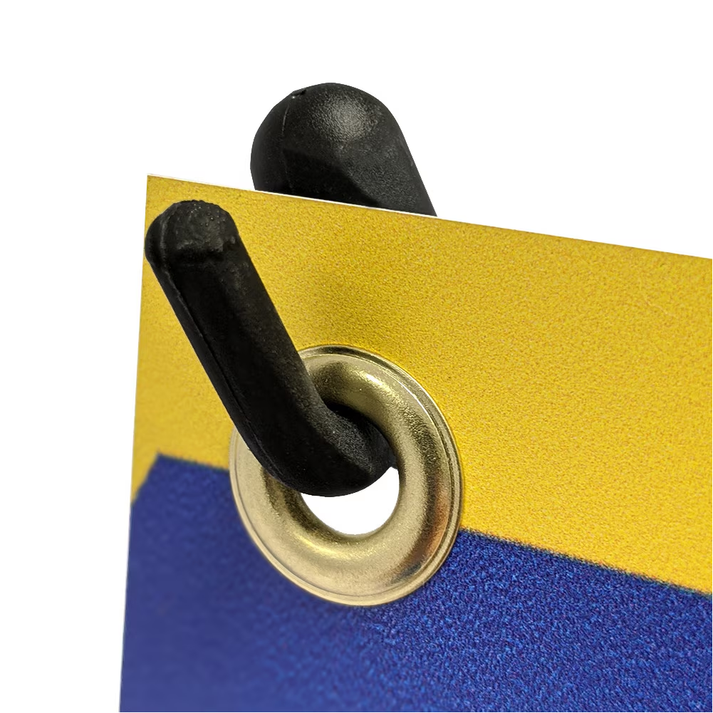 Close-up shot of a durable black plastic corner hook slotting securely through a gold metal banner grommet.⁠